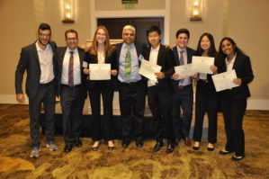 _DSC0932 A group of people standing together, dressed in business attire, holding certificates and smiling at a ceremony or event.